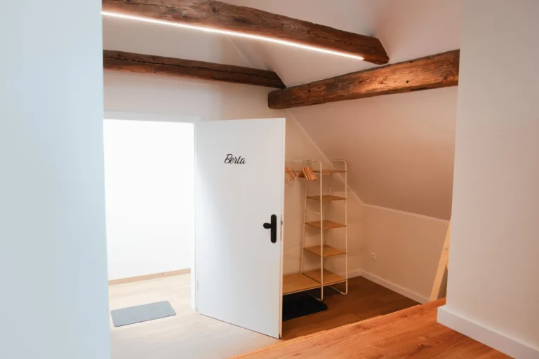 Eingangsbereich der Ferienwohnung Berta auf dem Ilsehof mit geöffneter Tür und Garderobe