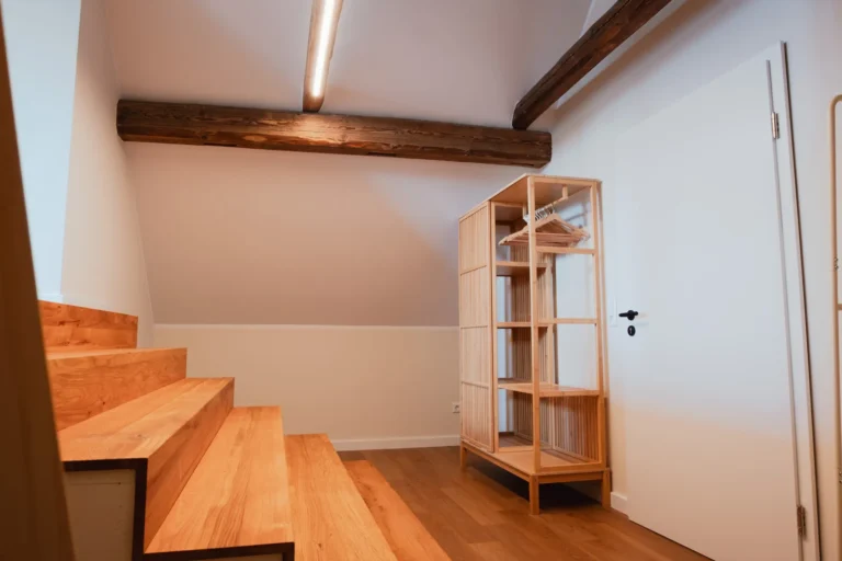 Garderobenbereich mit offener Holzstruktur und Eingangstür in der Ferienwohnung Berta