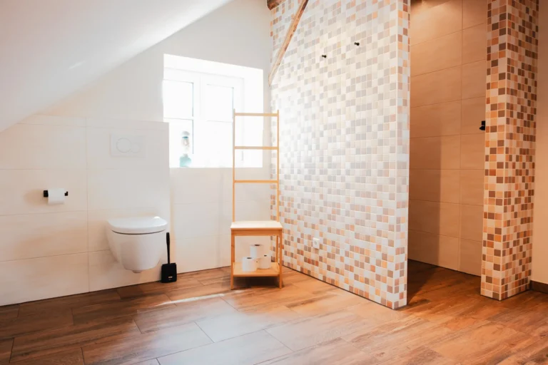 Helles Badezimmer in der Ferienwohnung Berta mit großer Dusche, naturfarbenen Fliesen und Fenster.