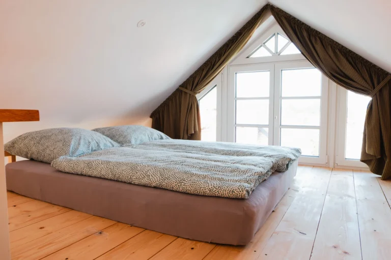 Offener Schlafbereich über dem Wohnbereich der Ferienwohnung Berta mit Doppelbett und großer Fensterfront