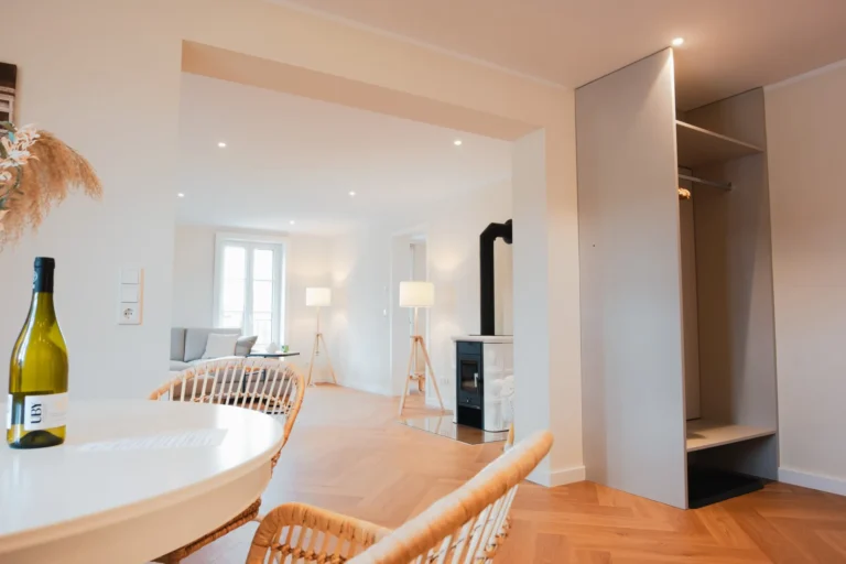 Essbereich der Ferienwohnung Ruth mit Blick auf den Wohnraum mit Kamin und großer Couch.