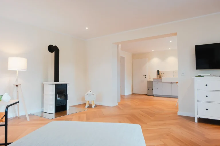 Wohnbereich mit Kaminofen und Blick ins Schlafzimmer der Ferienwohnung Ruth.