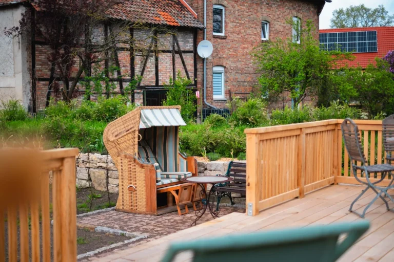 Strandkorb und Sitzgruppe am Tiny House Mimi mit Blick auf Garten und Fachwerk