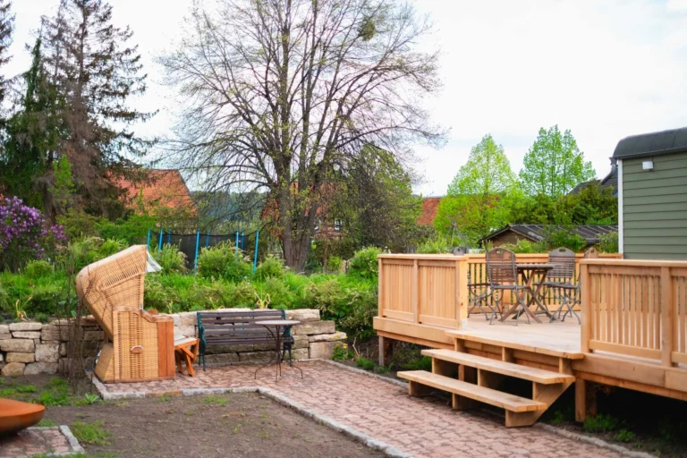 Holzterrasse des Tiny House Mimi mit Sitzbereich und Gartenansicht