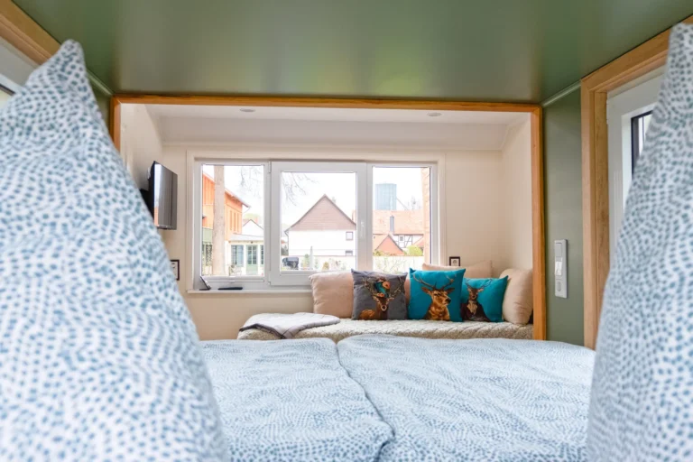 Blick vom Bett auf die Couch im Tiny House Mimi – Ilsehof Osterwieck, Harz